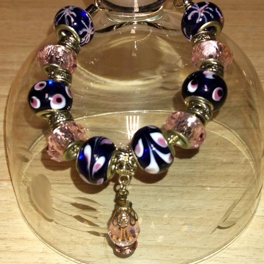 Looks like a Brighton charm bracelet..pink crystals with charms black,pink with